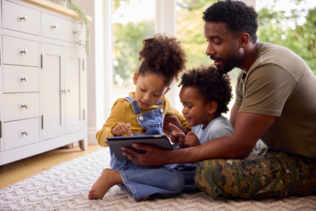 military father playing with his children on the floor
